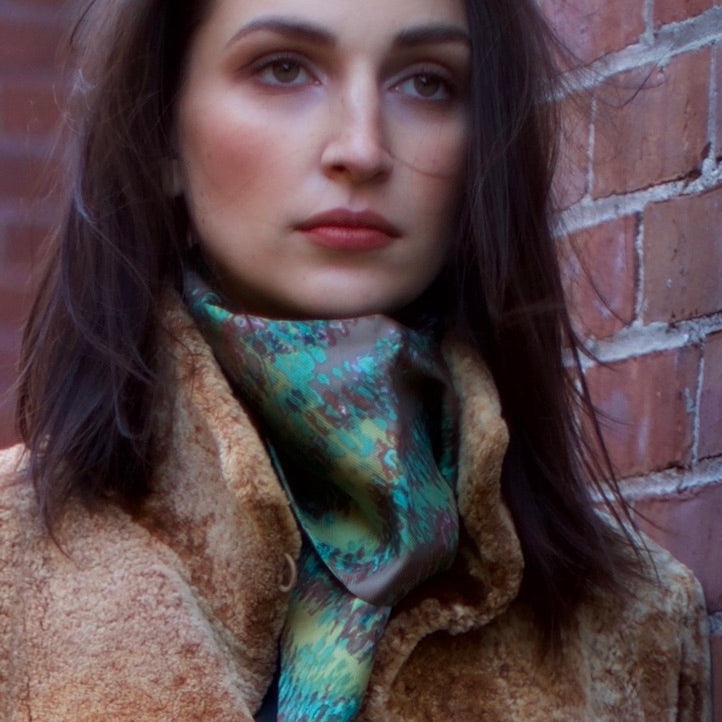 Model wearing a Darby Scott Silk Scarf outside with a brick wall background
