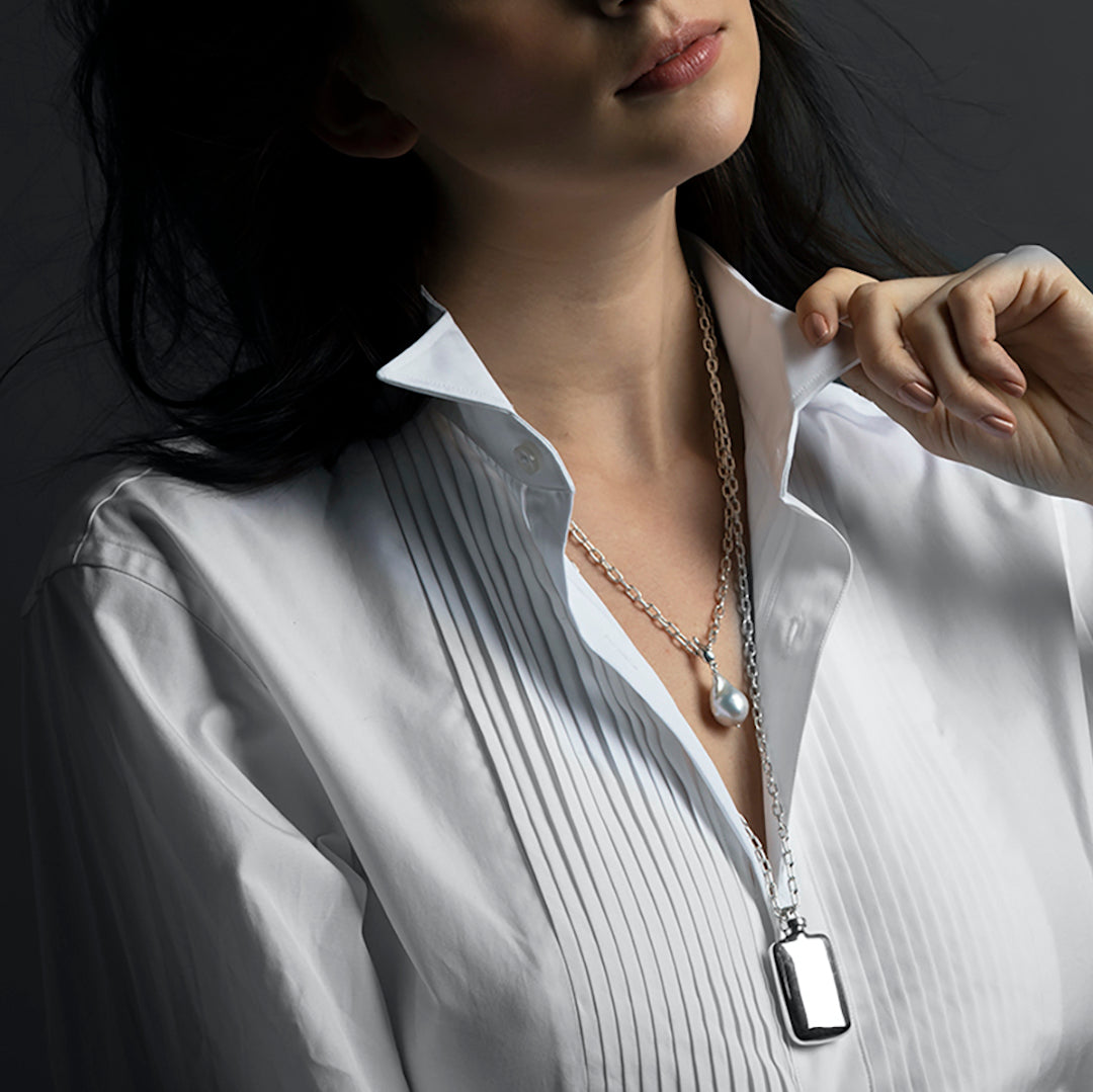 Model wearing a sterling silver perfume pendant and a pearl pendant - Darby Scott