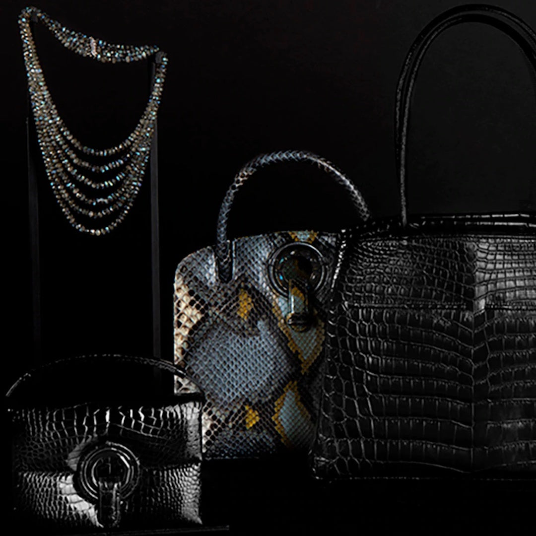 Black & blue handbags and jewelry in a moody setting - Darby Scott