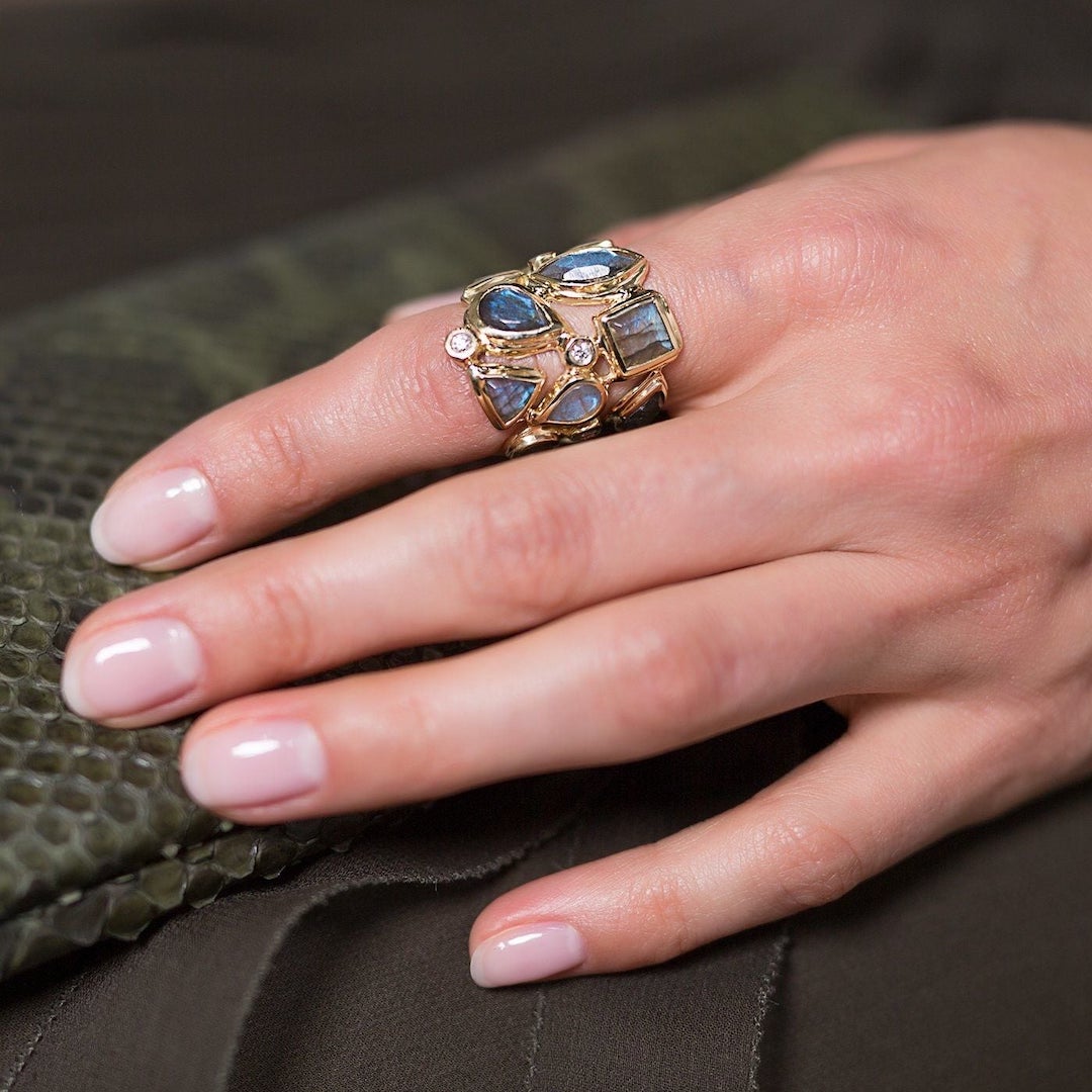 Labradorite and diamond mosiac ring on index finger of woman
