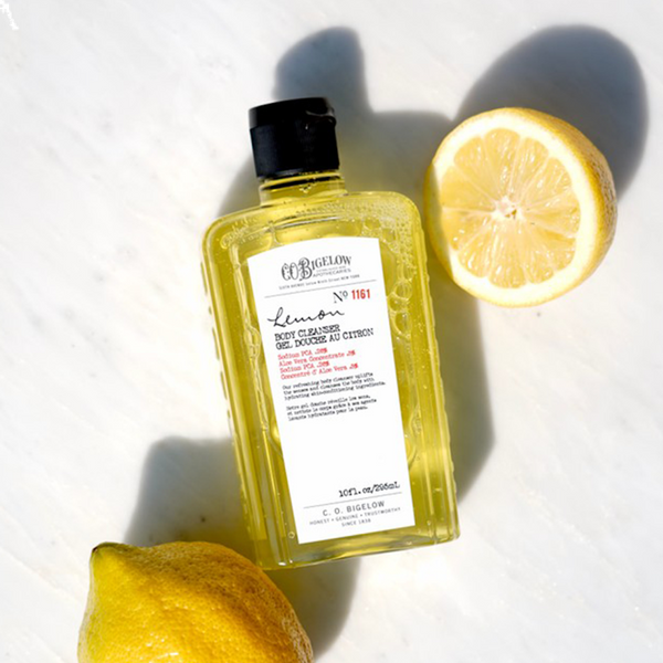 Lemon Body Cleanser bottle on table with lemons