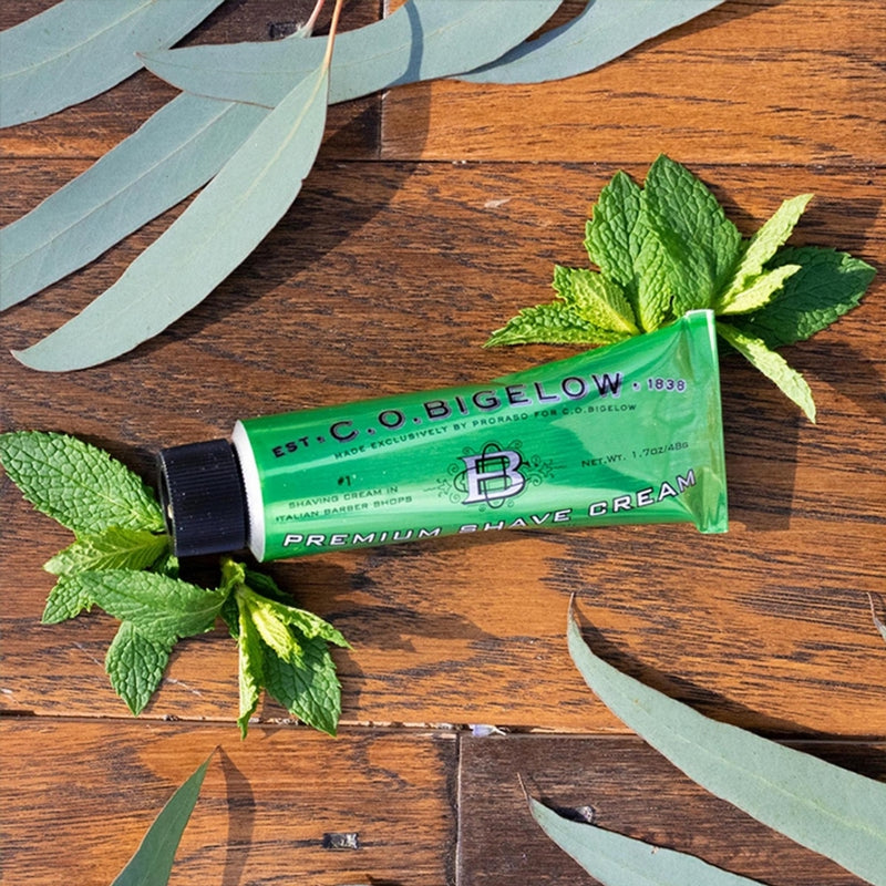 Tube of shave cream on table with herbs