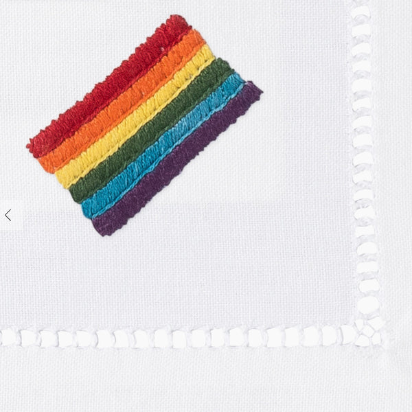 Detail of embroidered pride flag on corner of cocktail napkin